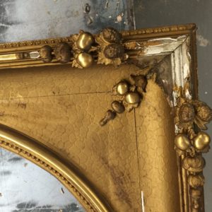 A frame with missing acorns, leaves, other cast composition ornament